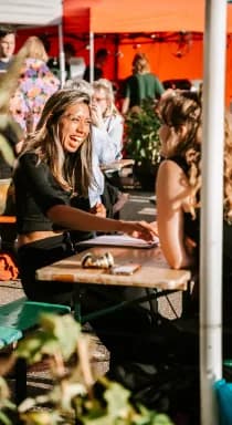 Twee gasten in gesprek aan een picknicktafel op een event