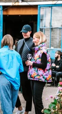 Gasten met een glas wijn op de binnenplaats van een eventlocatie