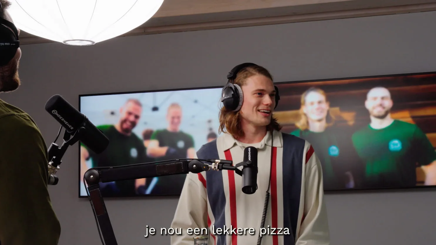 Een van de oprichters met koptelefoon achter de microfoon in de radiostudio