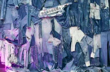 Wand vol spijkerkleding in paars licht als decor voor een themafeest