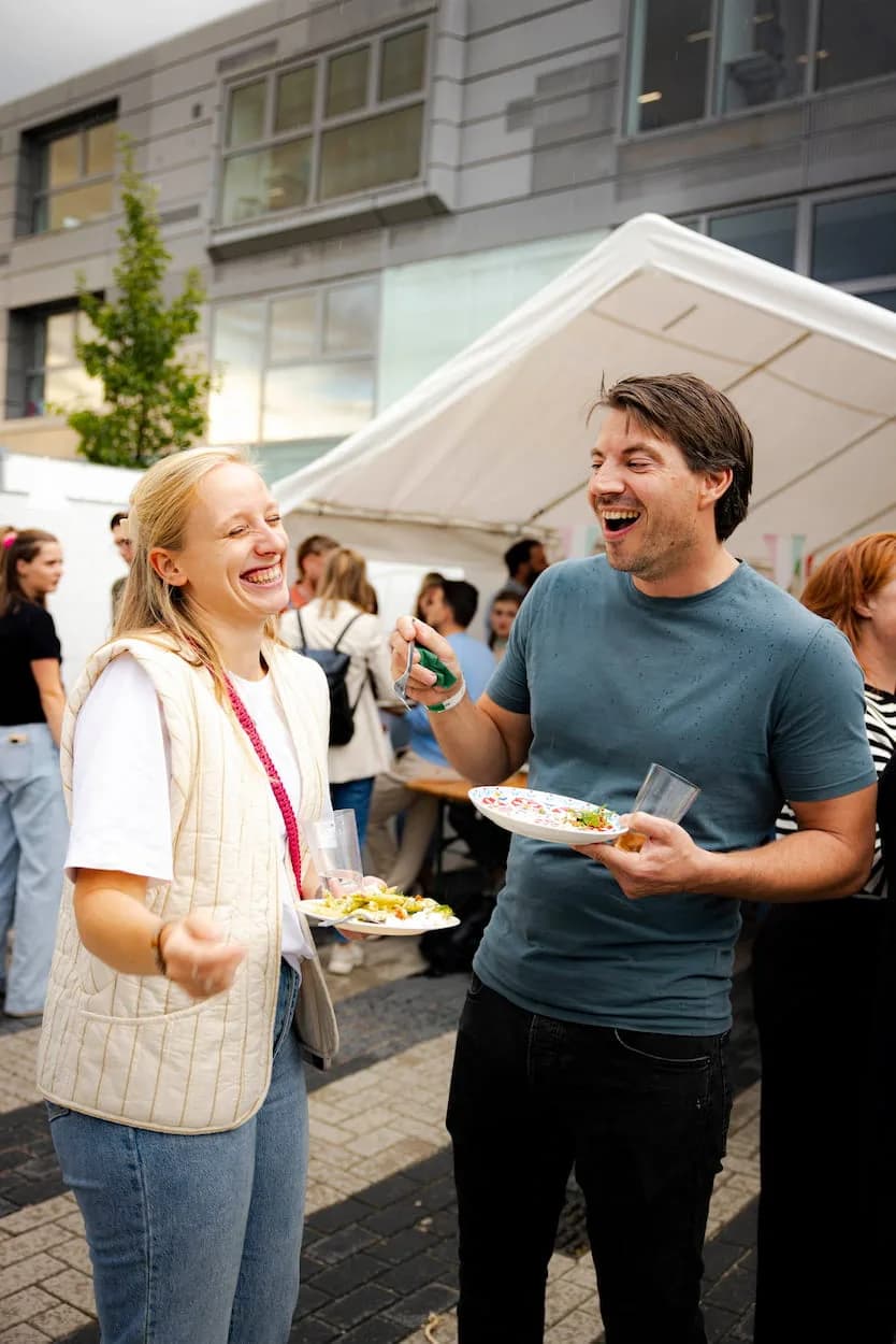Collega's met een pizza in de hand op een personeelsfeest