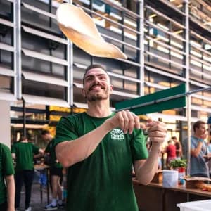 Pizzaiolo maro gooit pizza in de lucht, een beleving voor de gasten