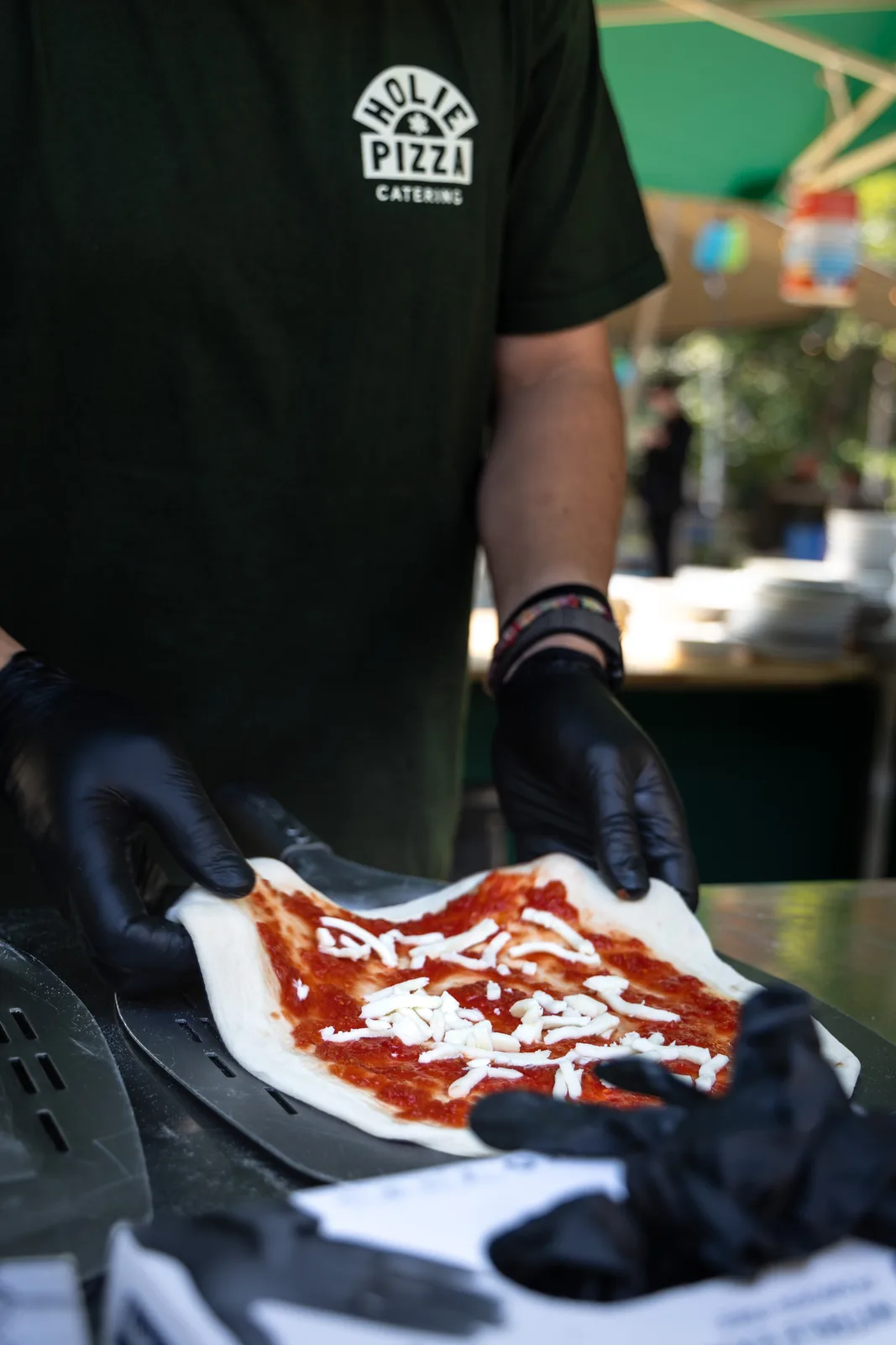 Pizzabakker legt een margherita klaar op de pizzaschep